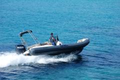 Gommone a noleggio ormeggiato nelle acque cristalline di Villasimius, Sardegna.