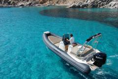 Gommone a noleggio ormeggiato nelle acque cristalline di Villasimius, Sardegna.
